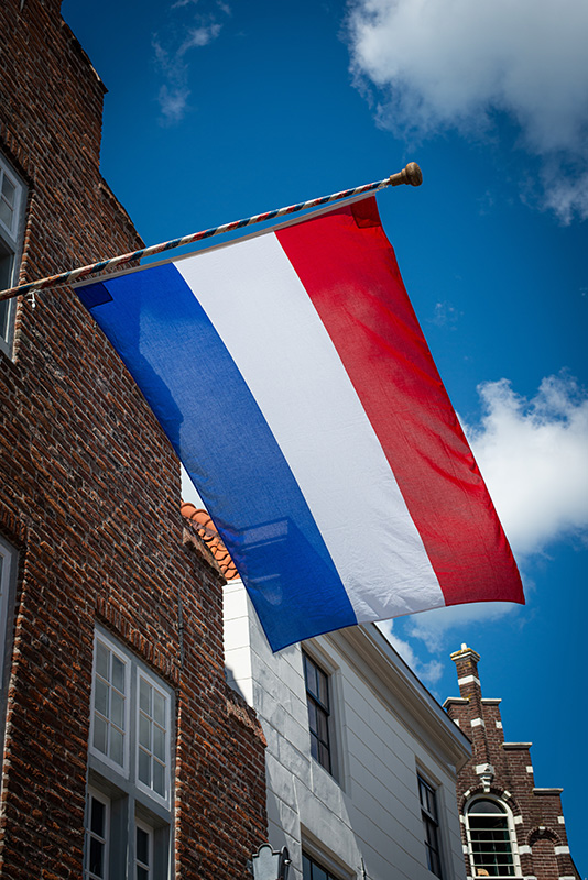 Nederlandse vlag met een blauwe lucht als achtergrond