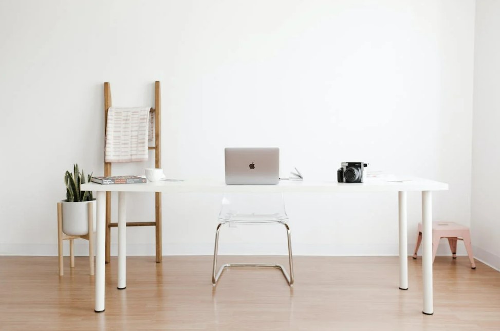 Witte muur met een wit bureau en het een en ander aan decoraties